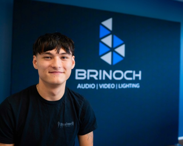 Nathan Griffiths gained hands-on technical experience through his fall internship with Brinoch, a company specializing in audio, video, and lighting system integration.
 
As a senior contemporary music industry major with an interest in live sound production, Nathan explored the setup and installation of PA (professional audio) systems by building equipment racks, soldering connections, and assisting with installation projects on job sites. His experience with Brinoch strengthened key technical skills while also teaching him the importance of preparation before installation.
 
For Nathan, his time with Brinoch emphasized the importance of seizing opportunities to step beyond campus and engage directly with professionals in the field. “I think it’s really great to get out of the Bushnell dome and go out into local businesses and actually start doing what you want to do in a field that’s related to what you want to do,” Nathan reflected. “It’s just good to get out and connect with people in the industry that you’re wanting to be a part of.”
 
Great work, Nathan! 👏
Watch the video on the Bushnell University YouTube!
Read the full article on the Bushnell website!
