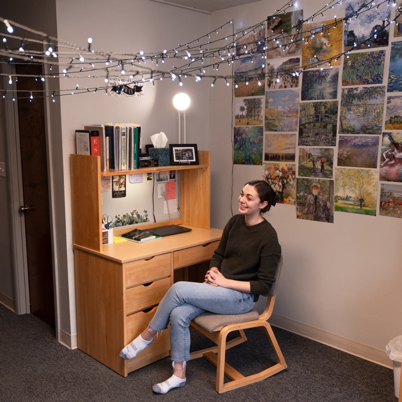 person sitting in chair in dorm room