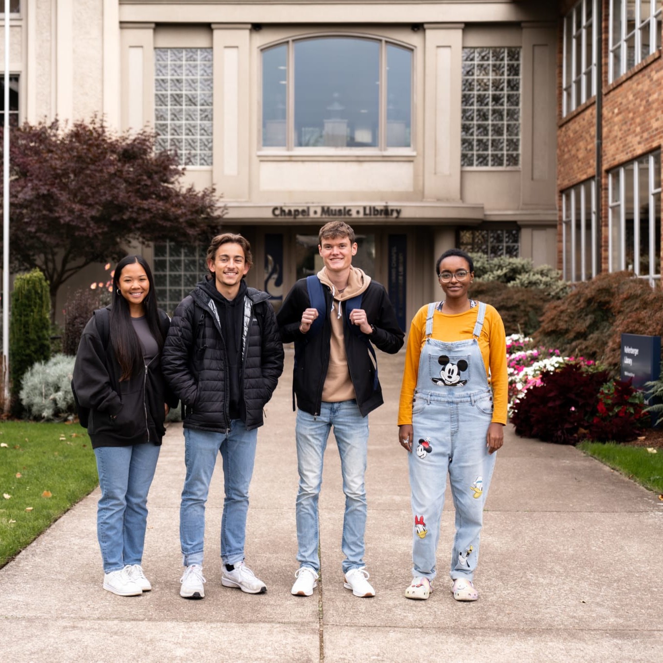 people walking outside on the sidewalk in front of a building