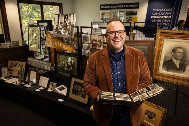 A person holding up a photo album in front of a pop up museum