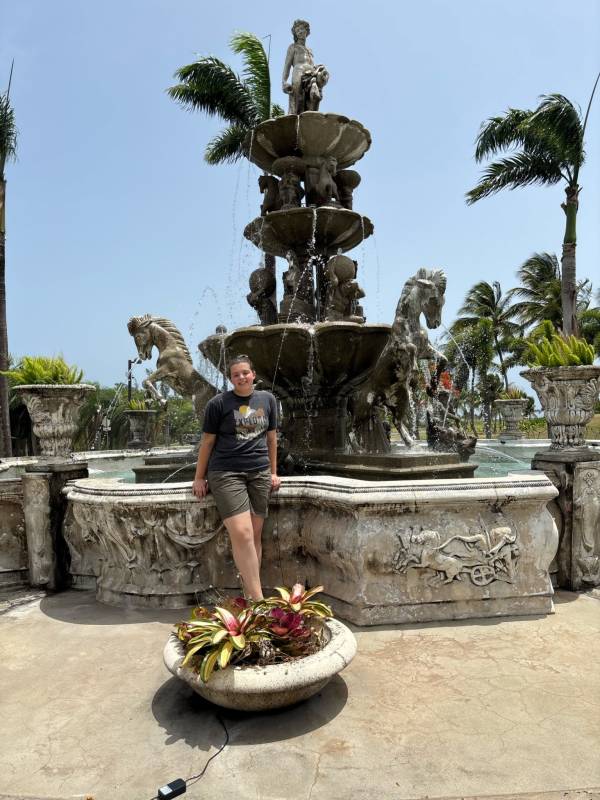 Person posing in front of a water fountain