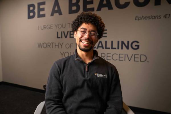 Person sitting in front of a wall with text