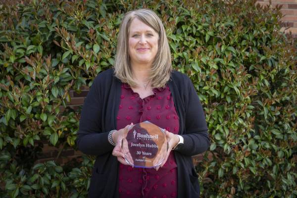 Person holding up an award outside